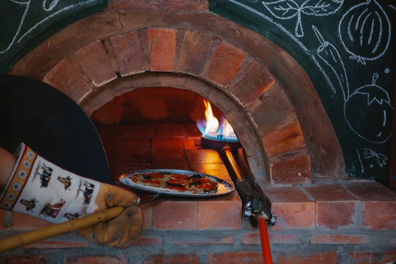 Fresh pizza coming out of the oven at luce pizza